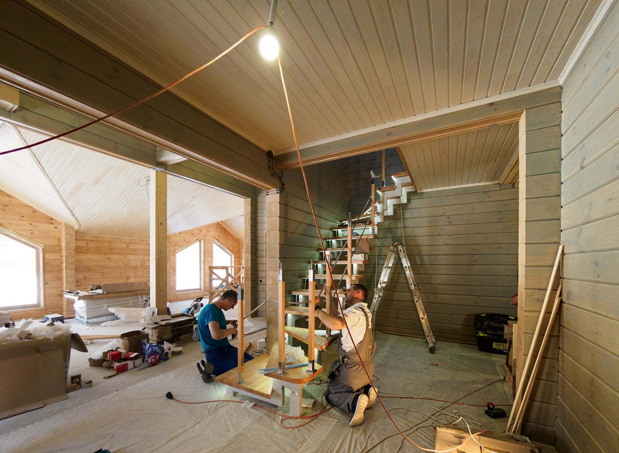 Carpenters building a staircase inside a new wooden home