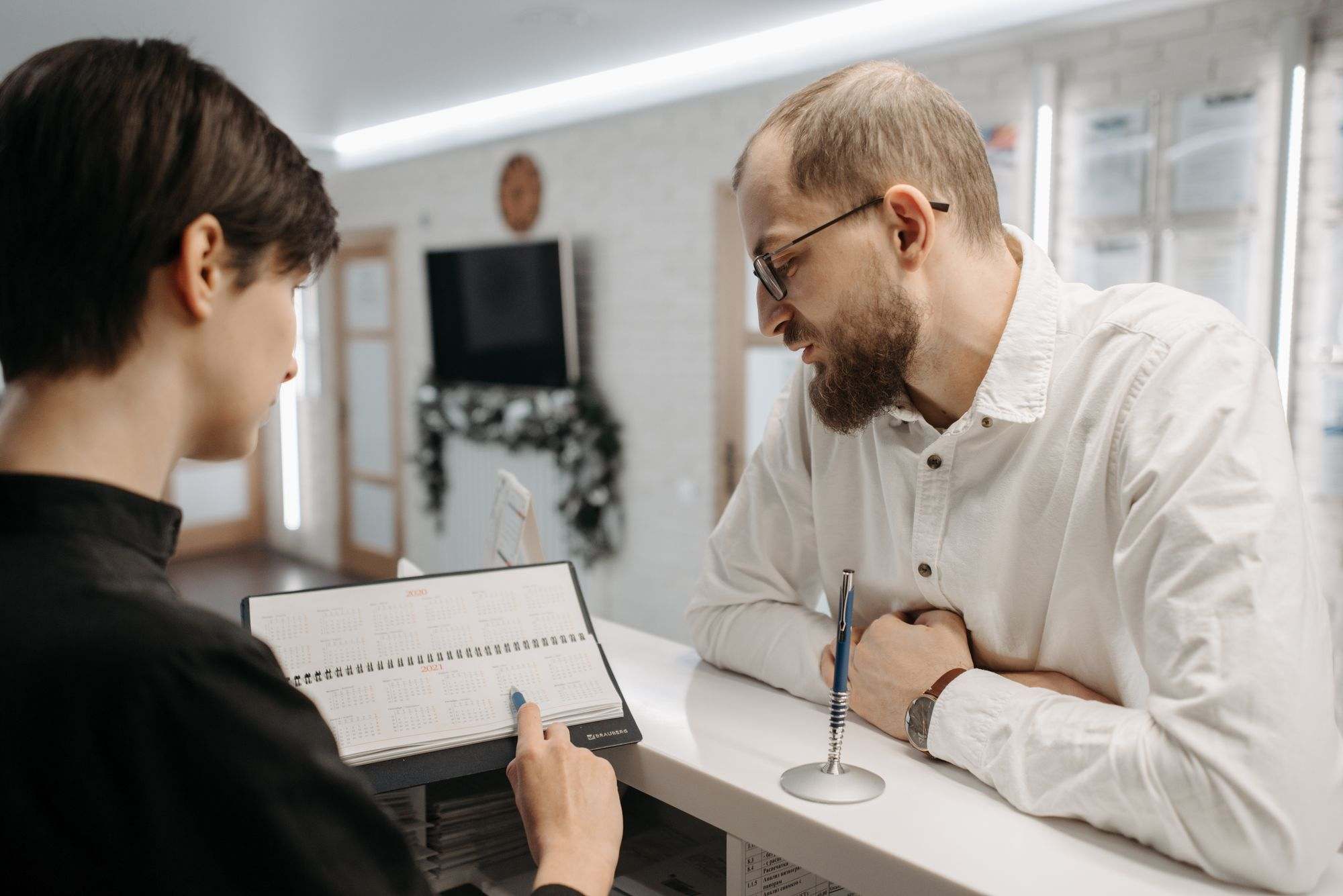 A receptionist helping a patient at a clinic front desk