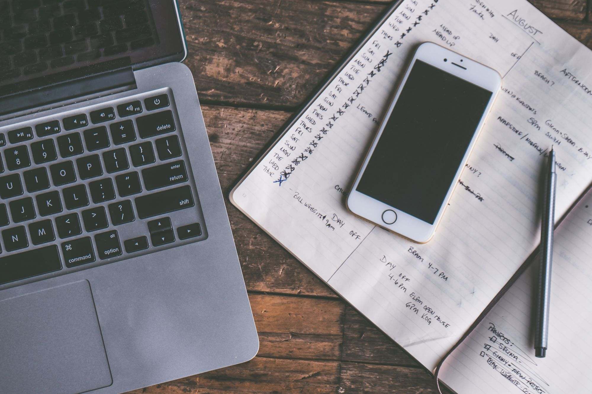 A laptop, smartphone and handwritten notes on a desk