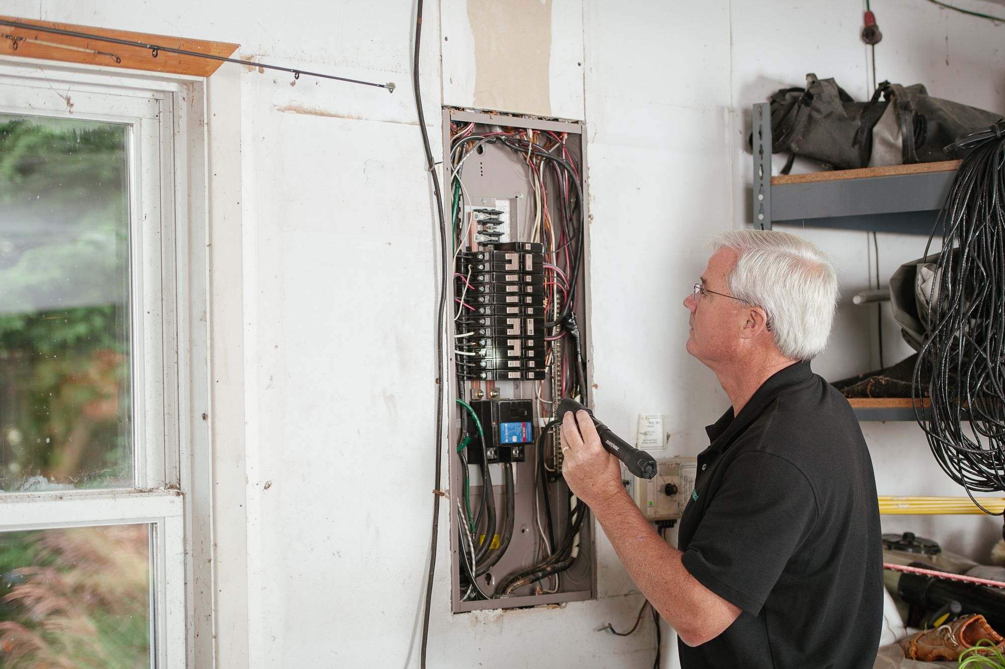 An electrician inspecting a home's breaker panel