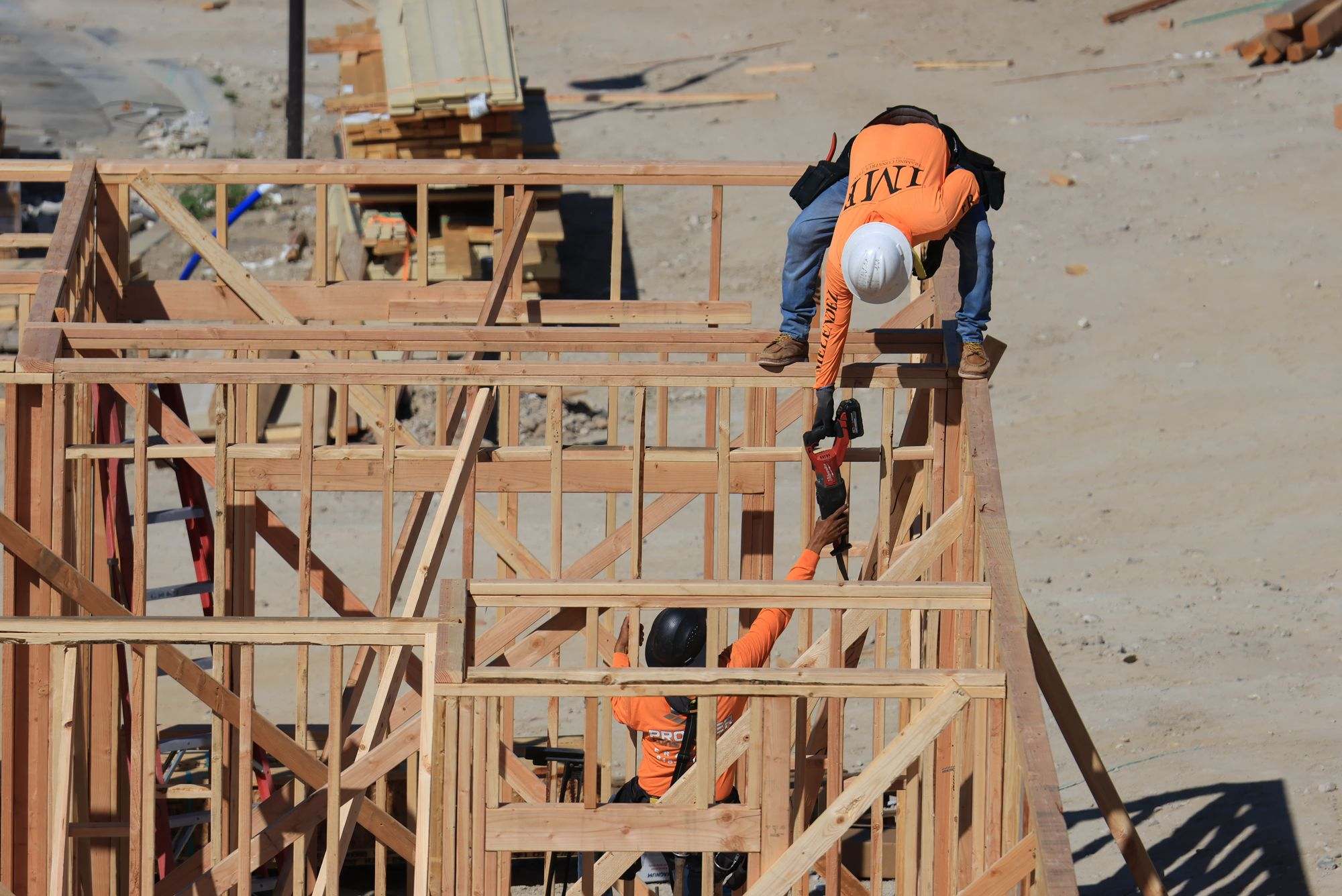 A framing crew working on a timber frame at a building site