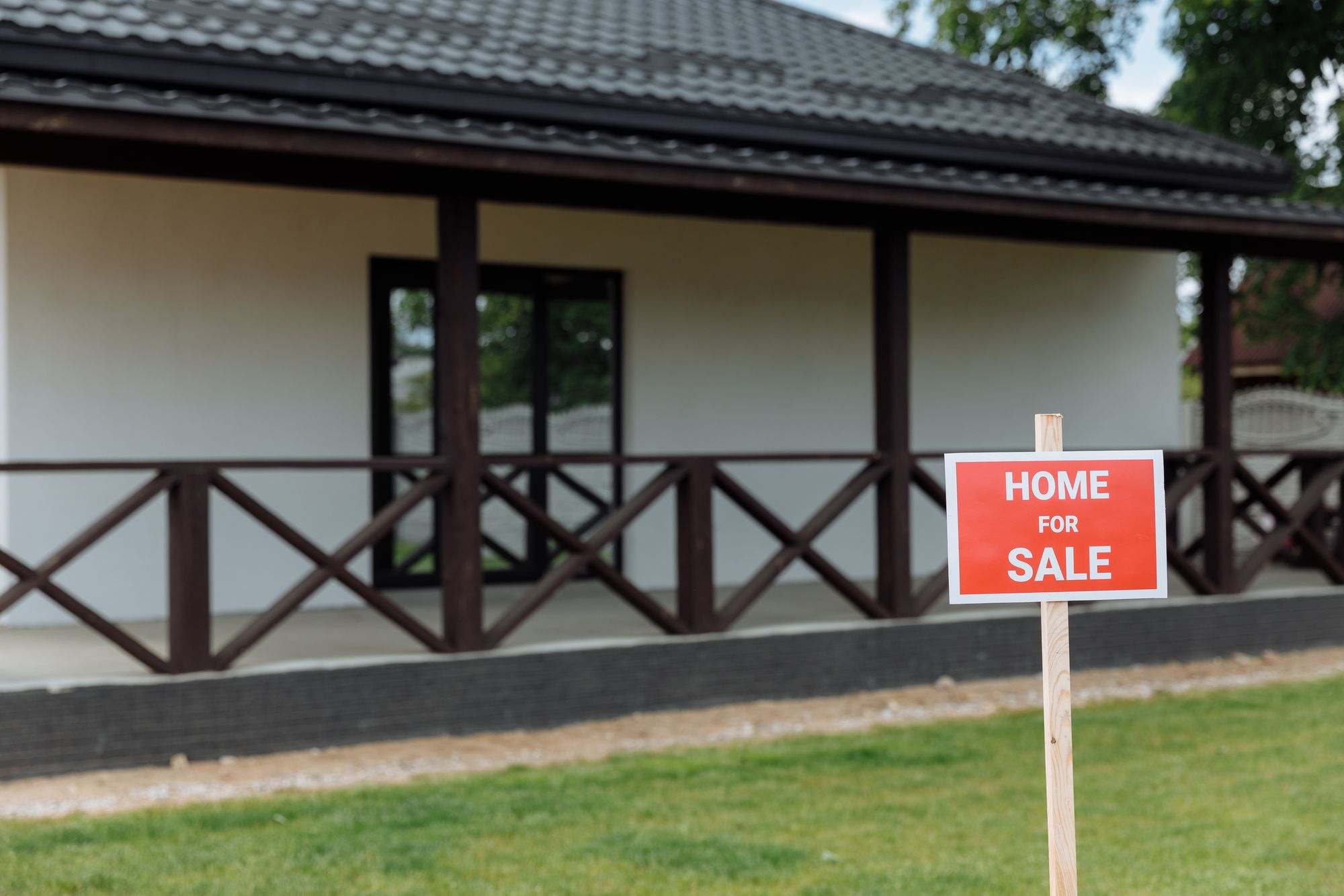 A home with a "Home for Sale" sign on the lawn
