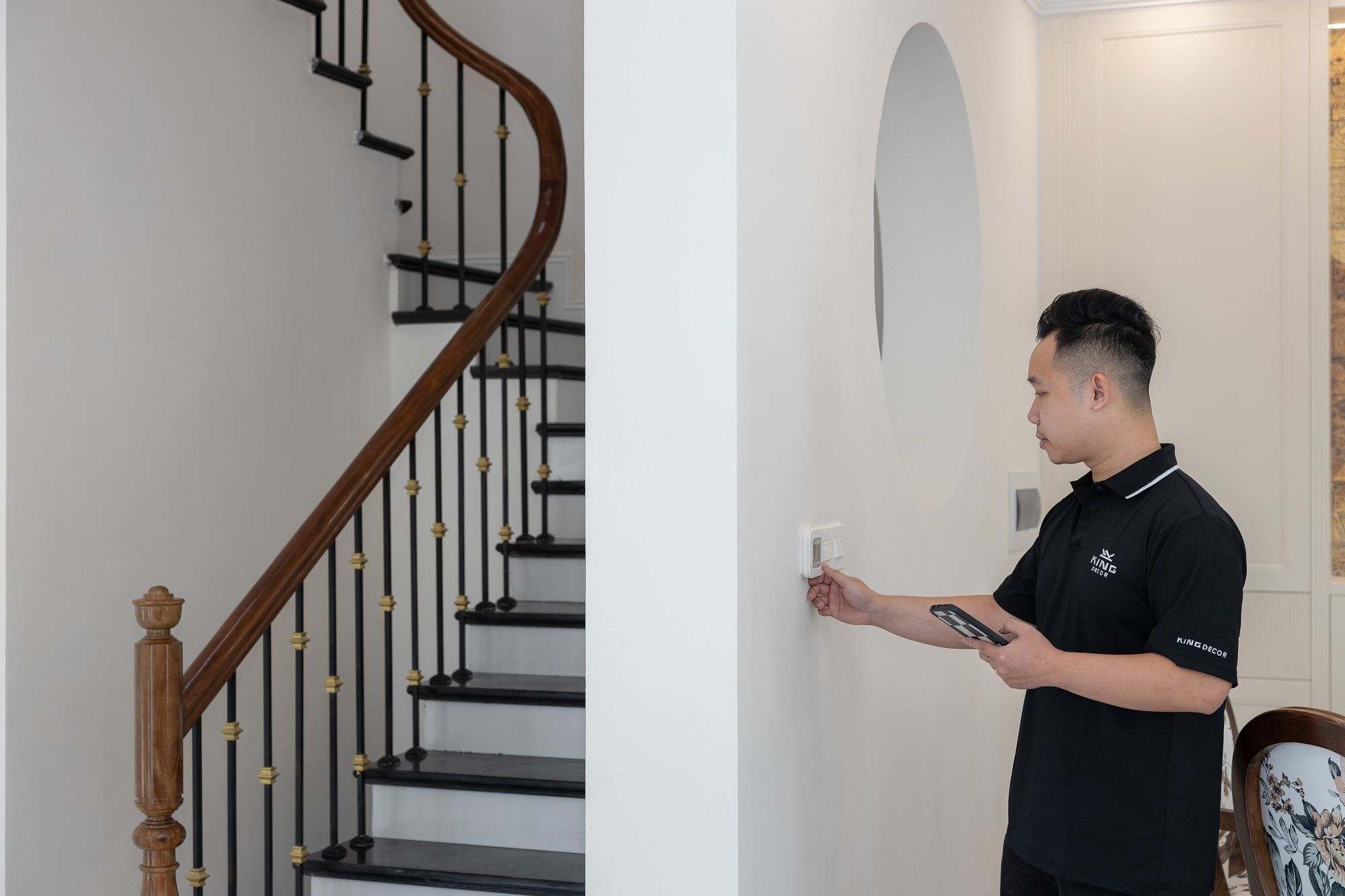 A technician checking a wall thermostat in a home