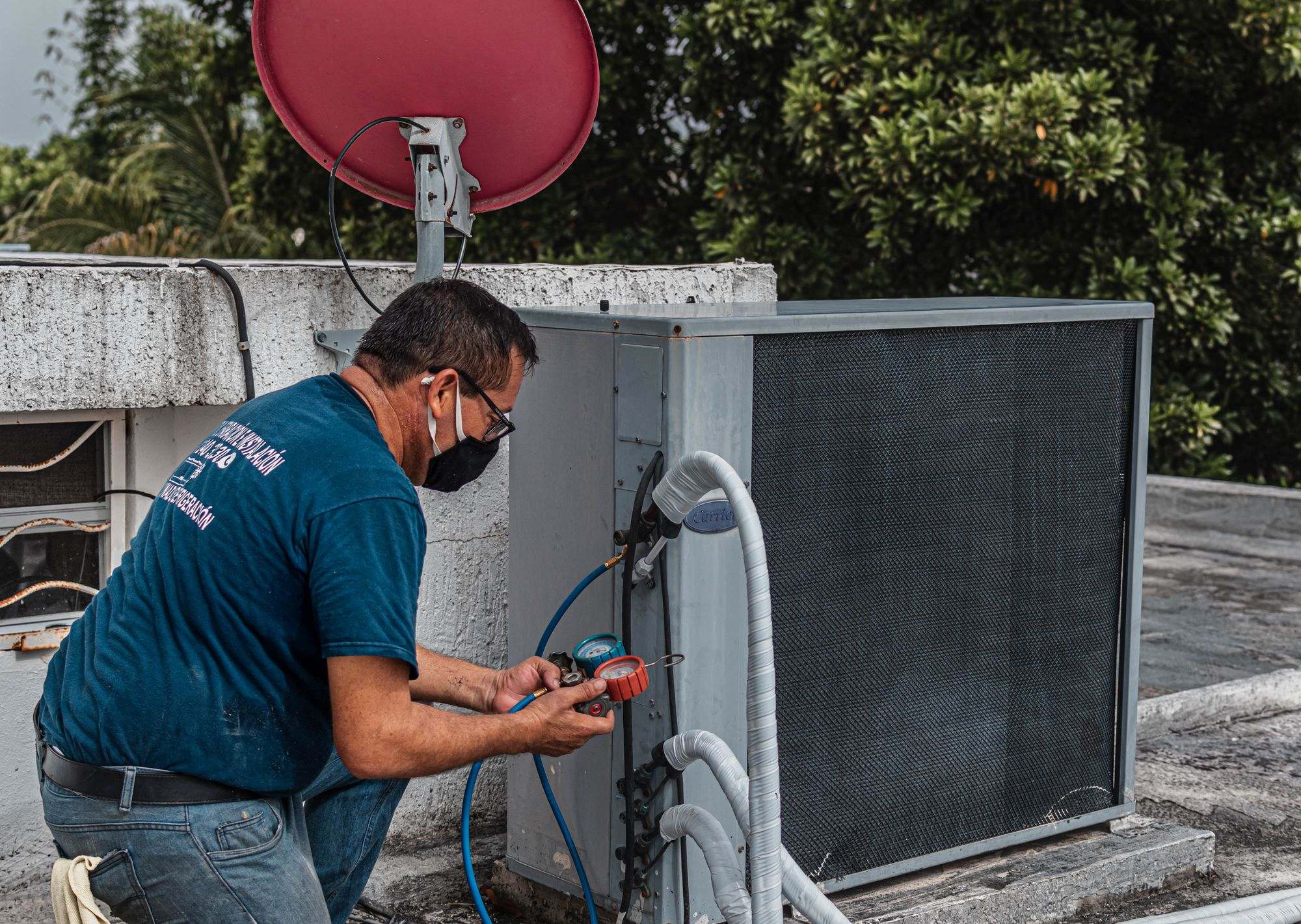 A technician checking an outdoor air-conditioning unit