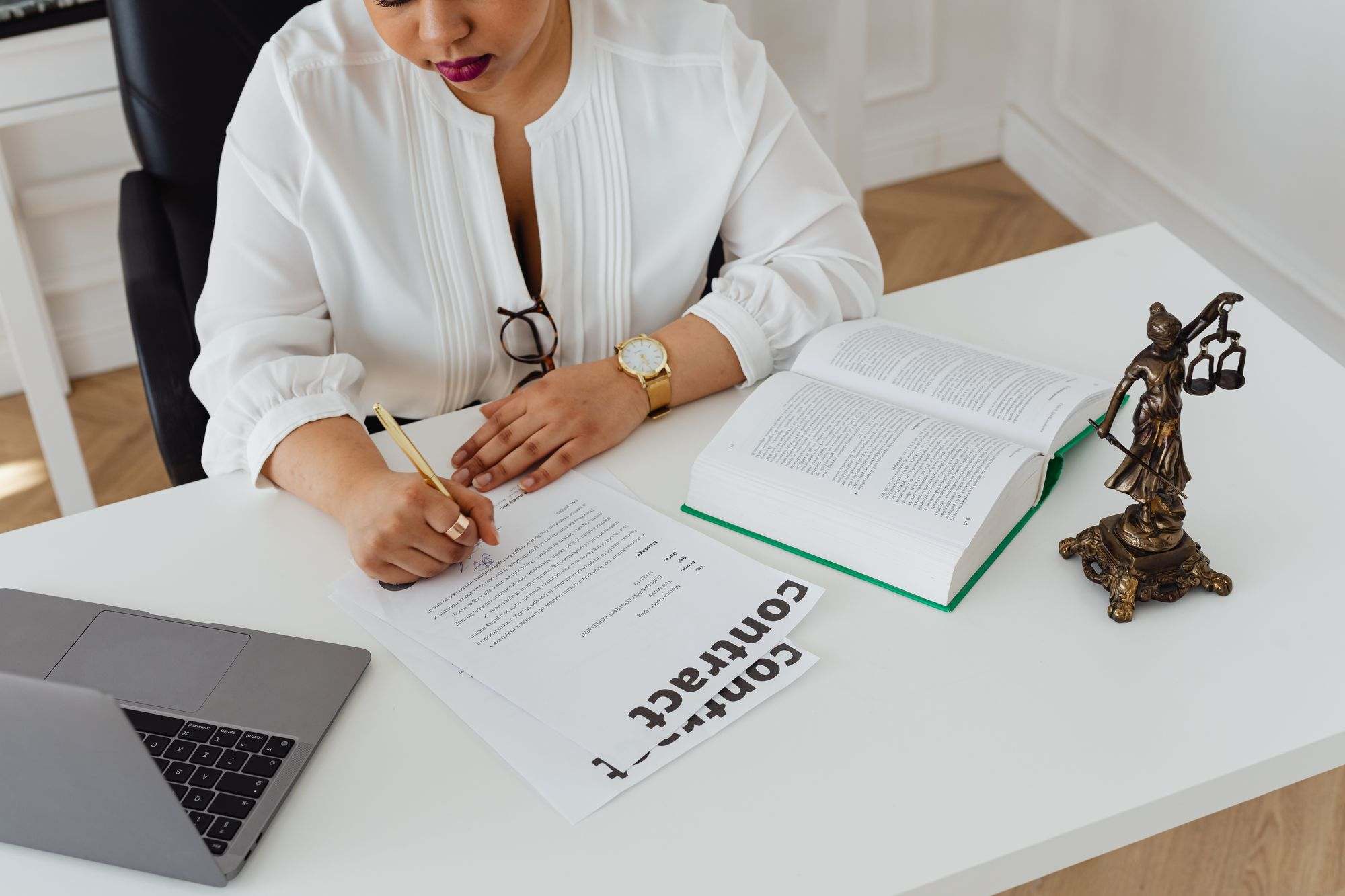 A lawyer reviewing a contract beside an open law book