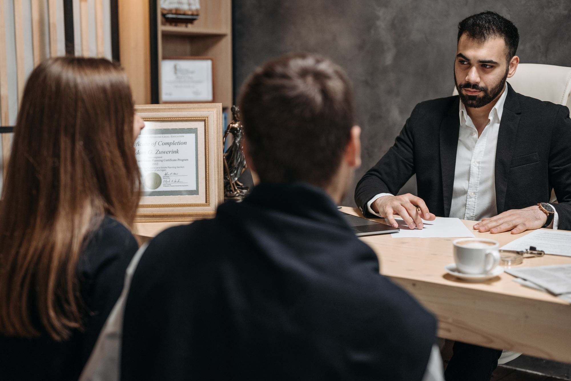 A lawyer at his desk meeting with two clients