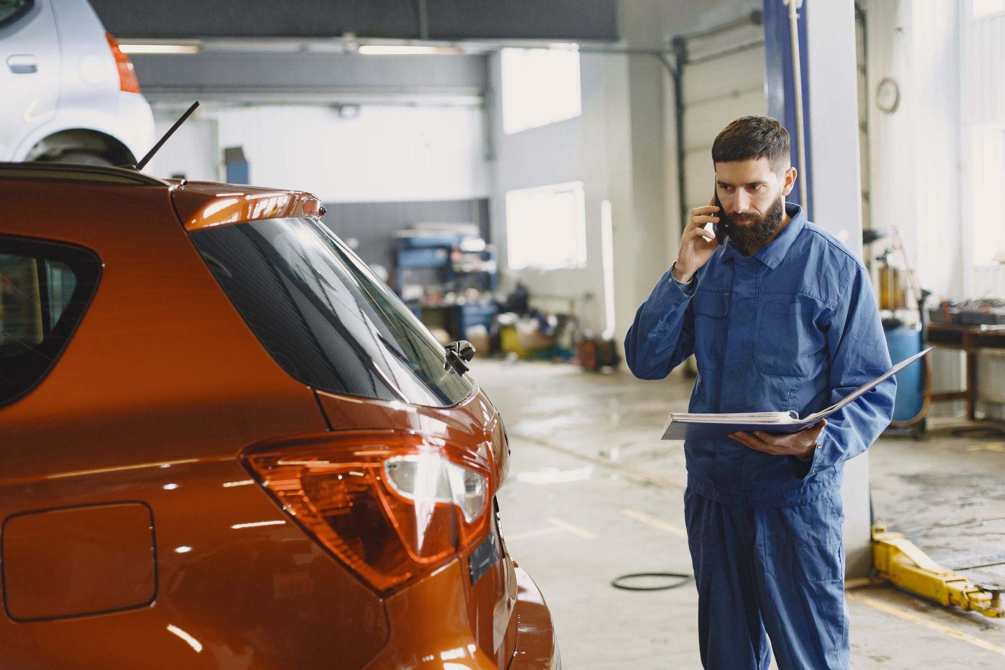 A mechanic taking a phone call in an auto repair shop