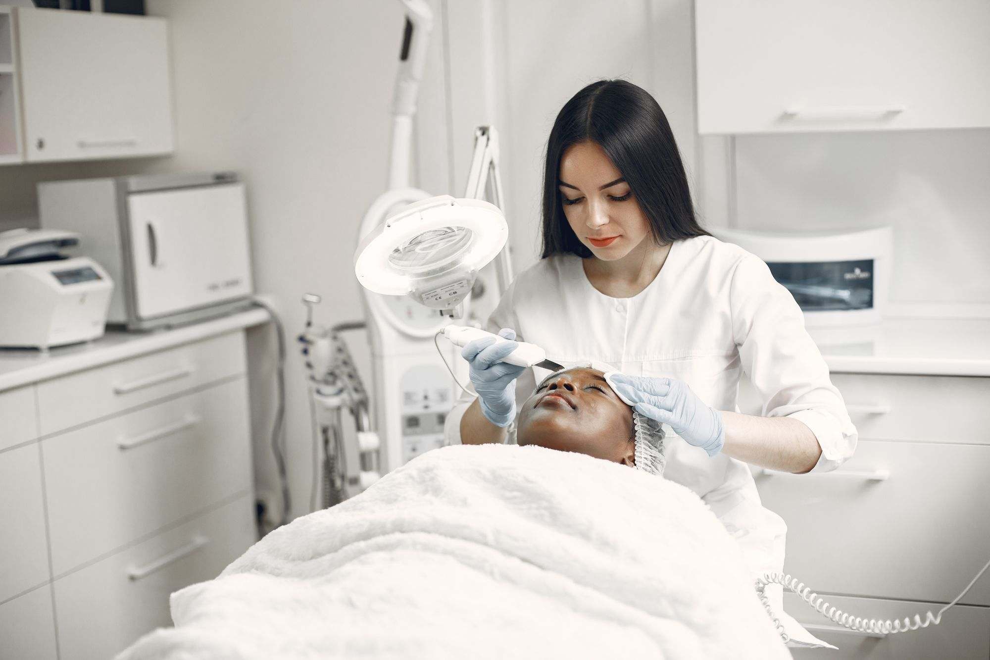 An aesthetician giving a client a facial treatment