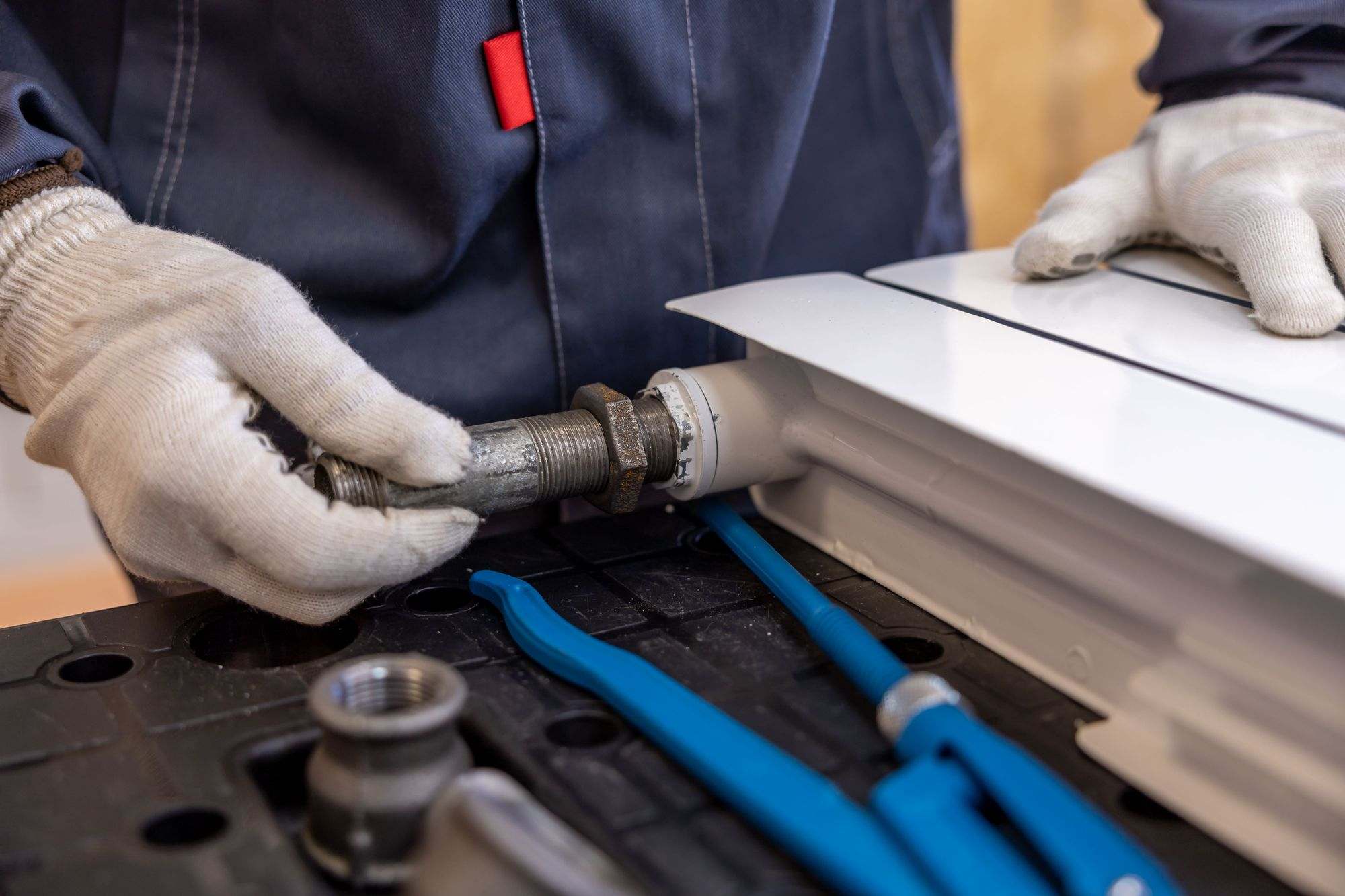 A plumber connecting a radiator pipe with a wrench
