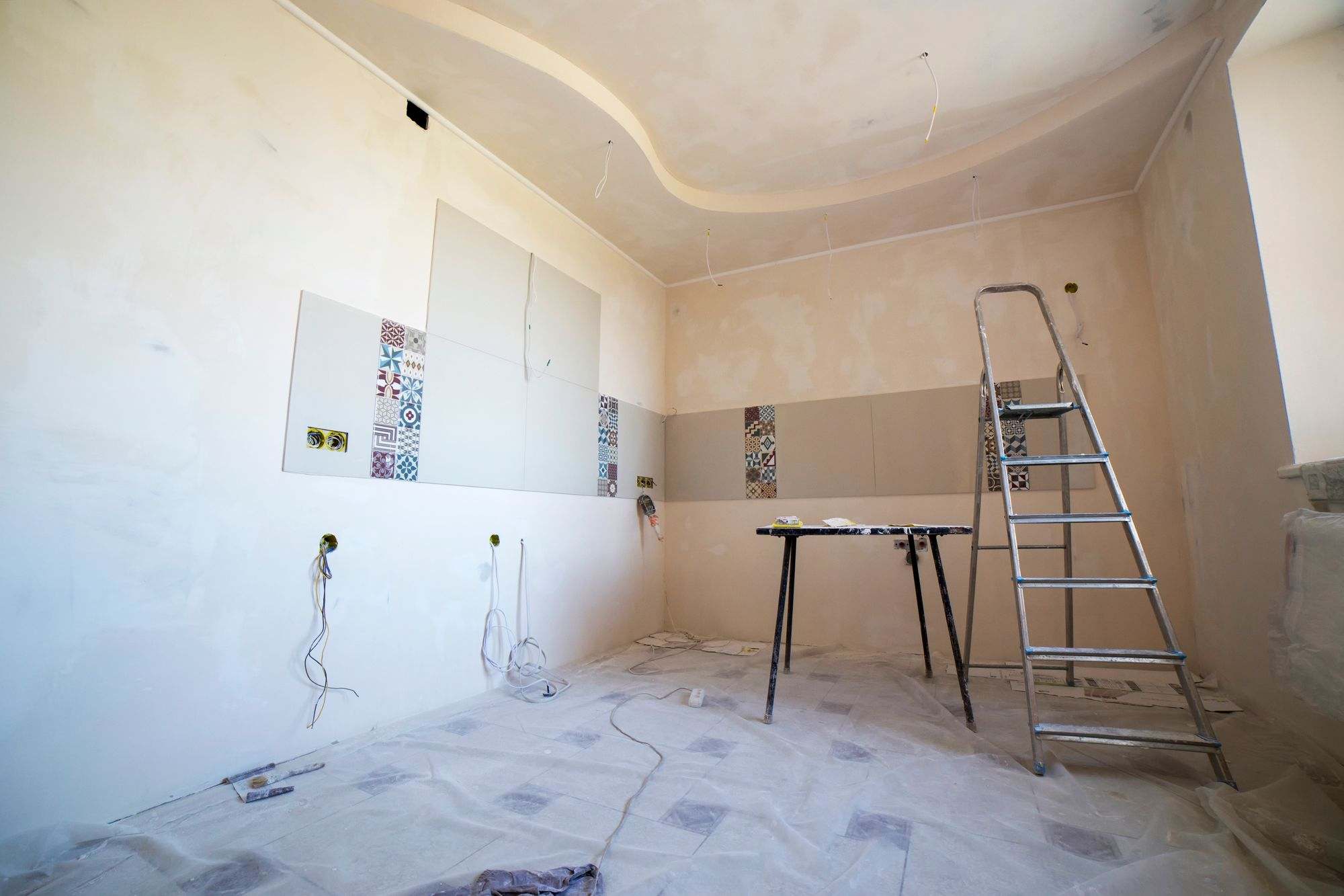 A room part-way through renovation with a ladder and fresh plaster