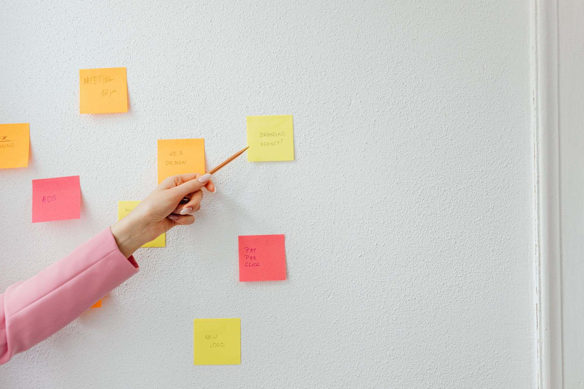 A hand pointing at planning notes on a wall