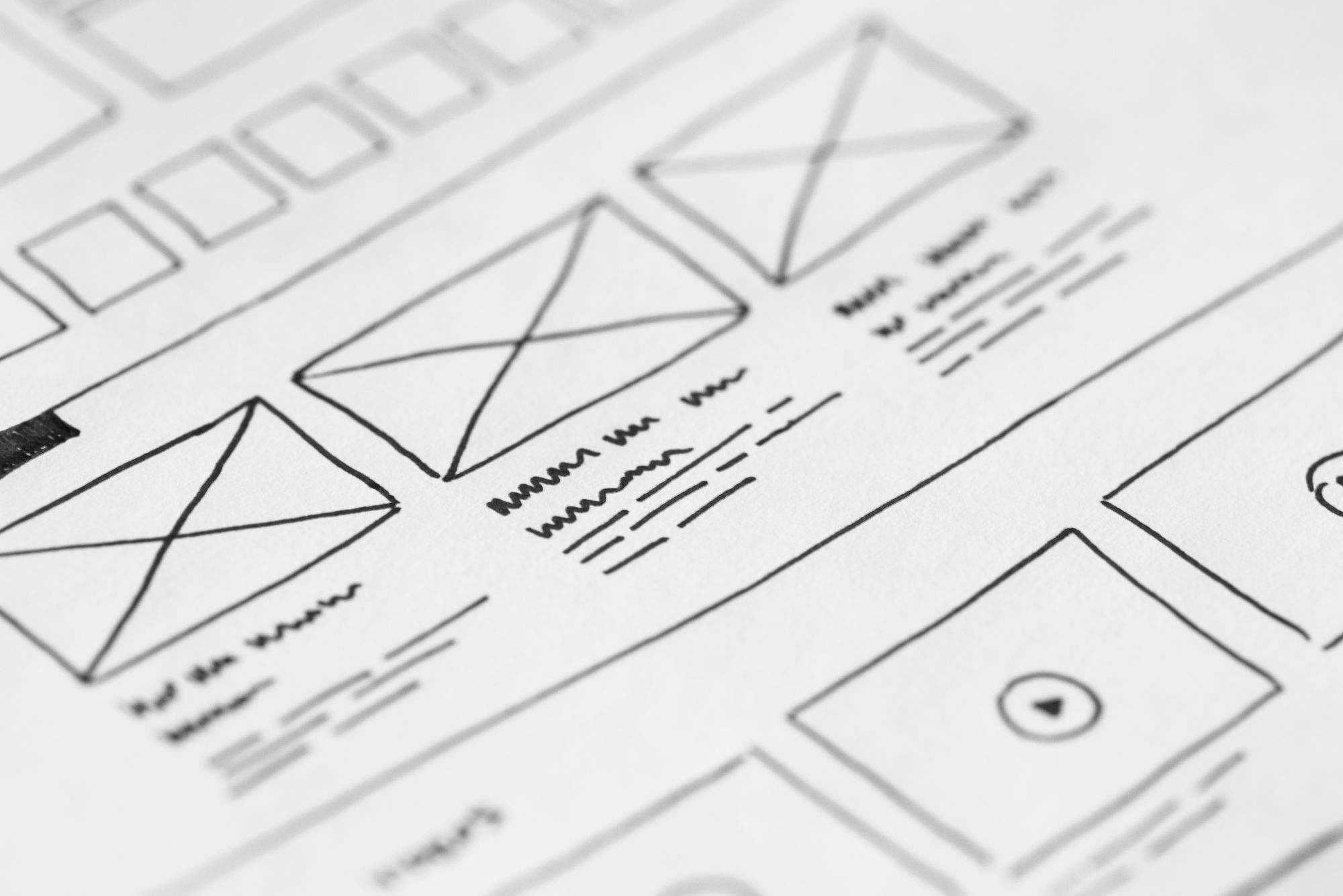 A hand-drawn website wireframe on paper